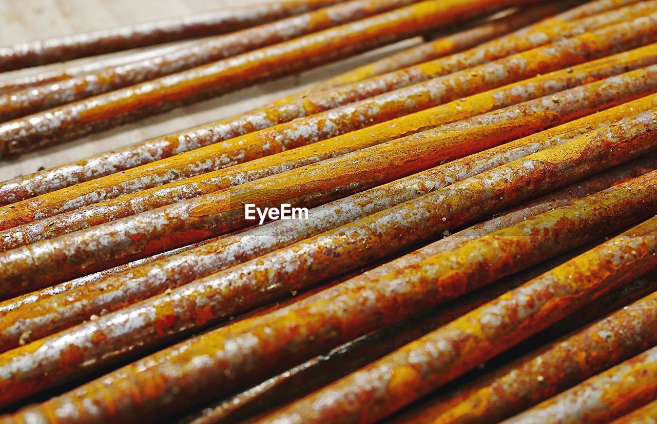 Texture of a group of rusty nails resting on a wooden surface on a construction site.