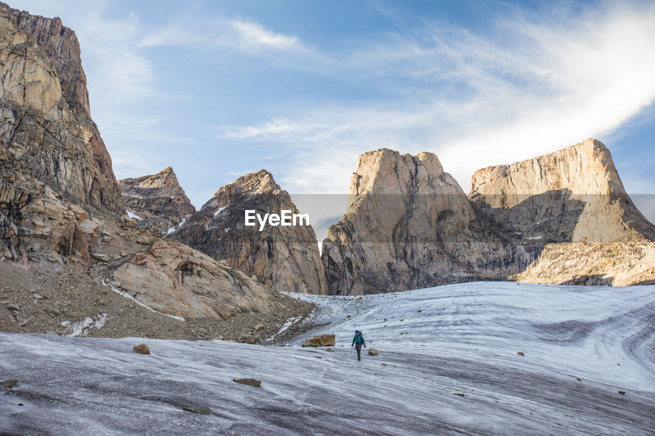 Mountain climber traverses a glacier below mount asgard.