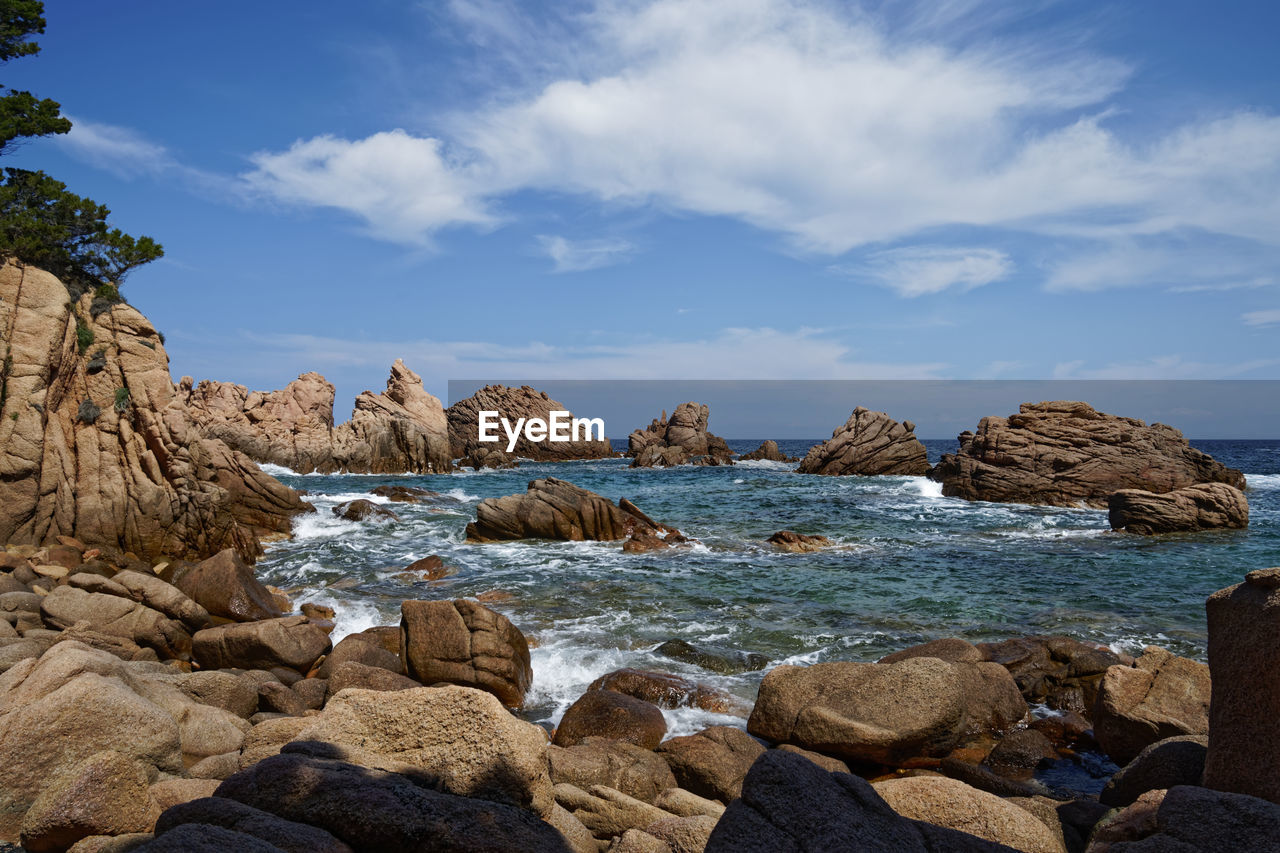 Rocks at beach against sky