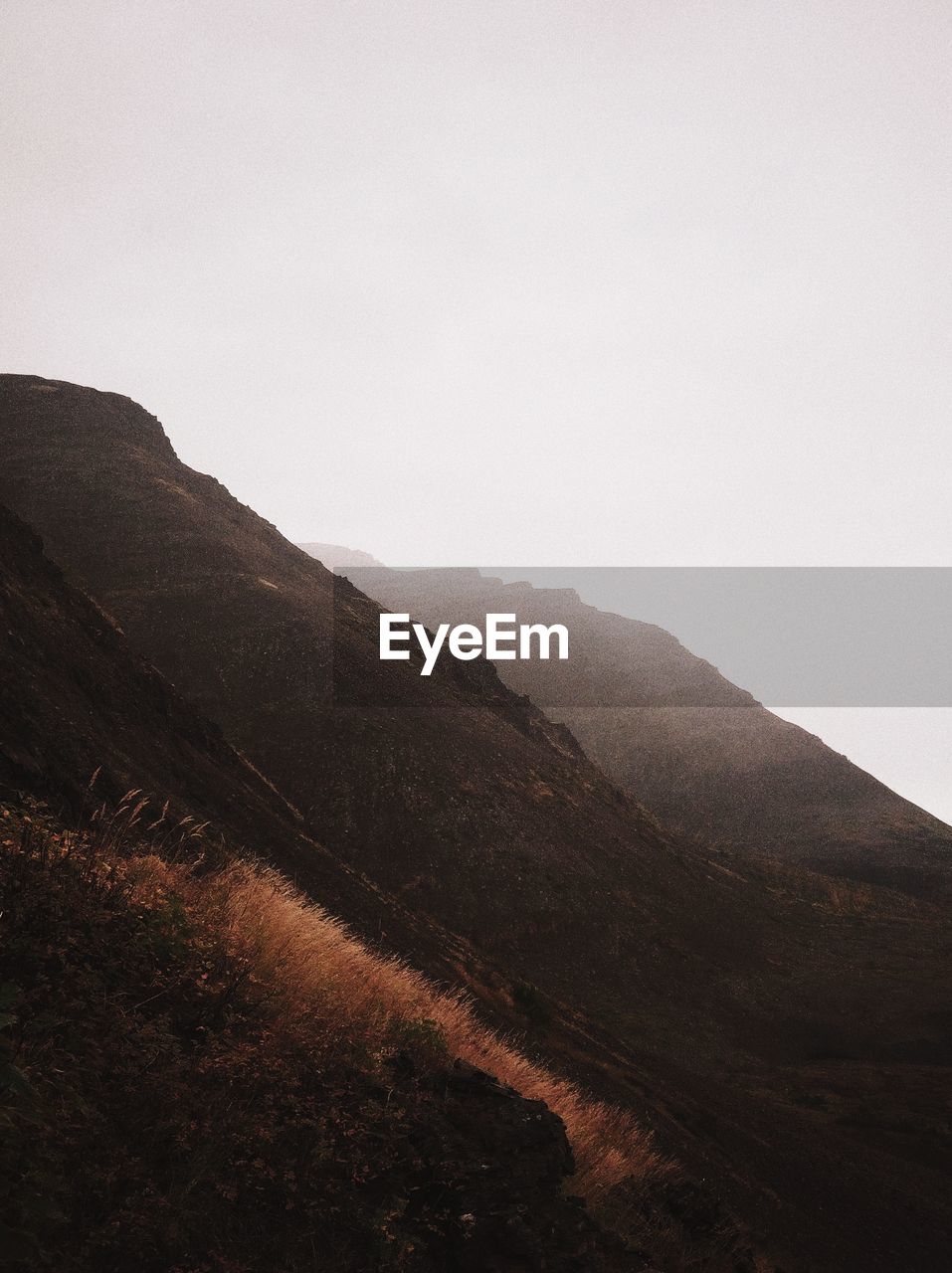 Scenic view of mountains against sky during foggy weather