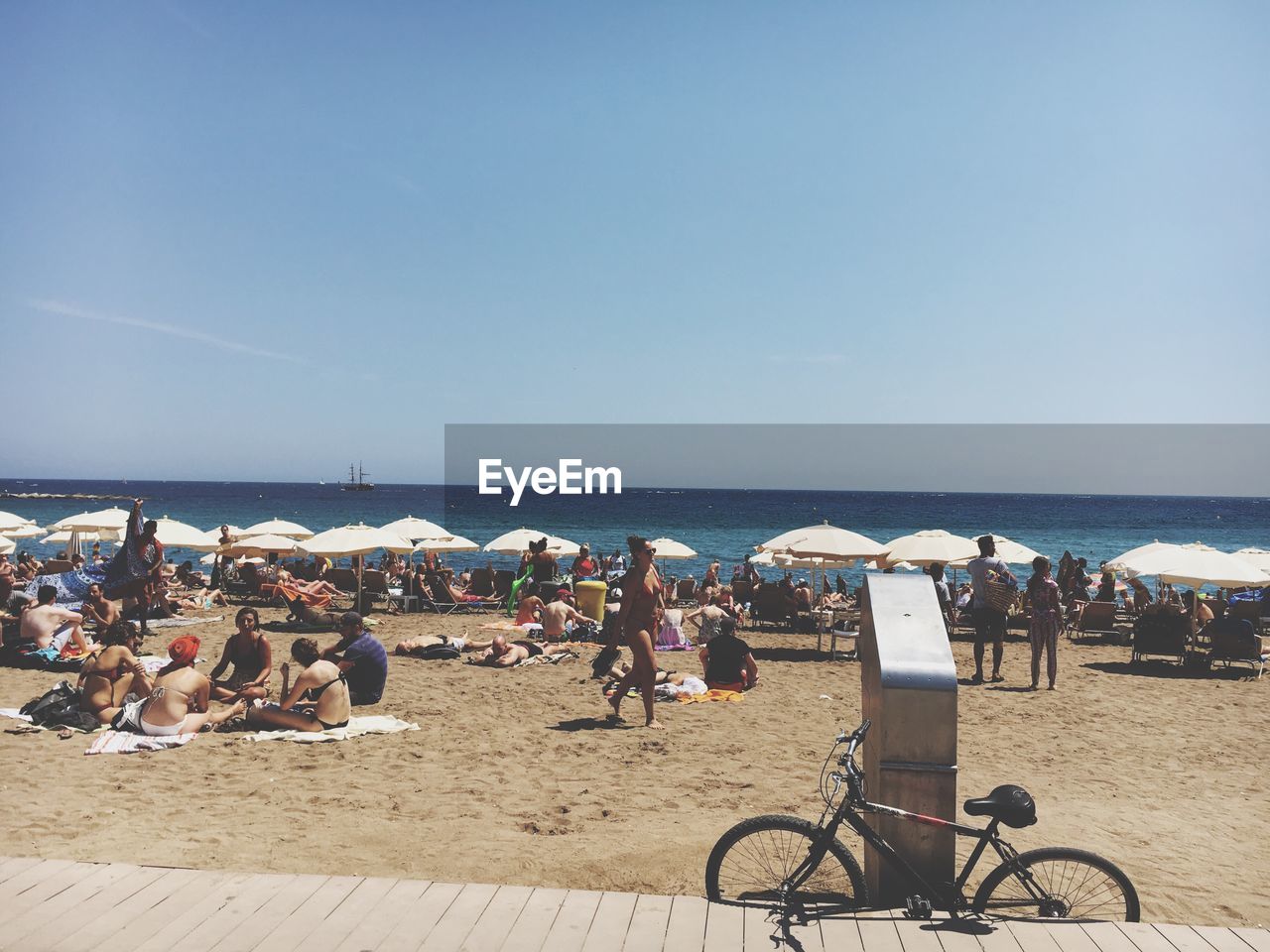 GROUP OF PEOPLE ON BEACH AGAINST CLEAR SKY