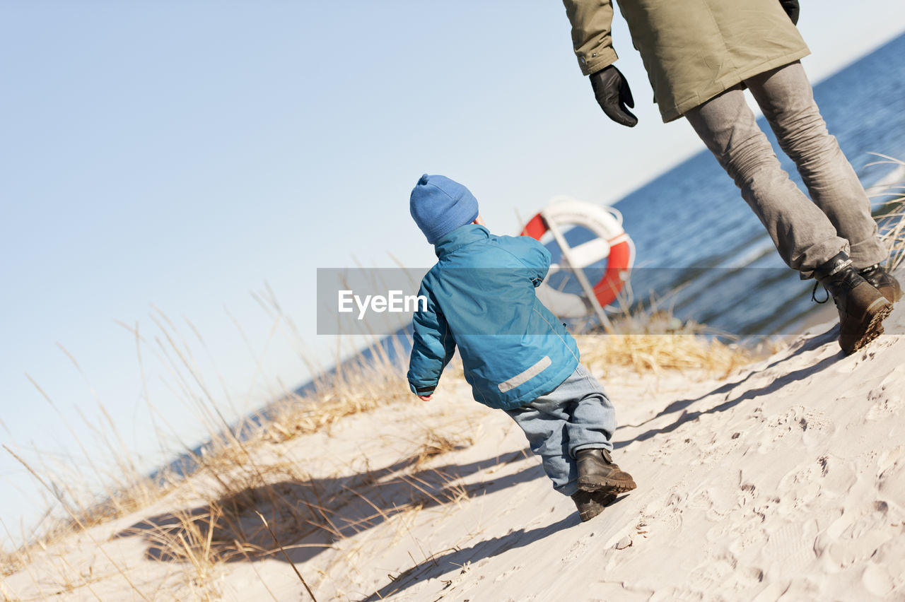 Boy exploring beach with his father