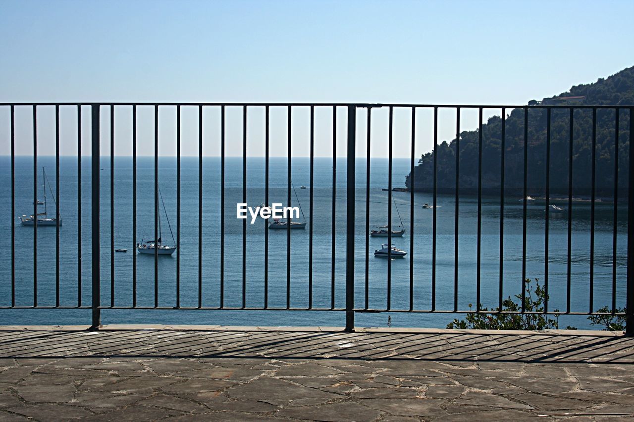 RAILING BY SEA AGAINST SKY IN CITY