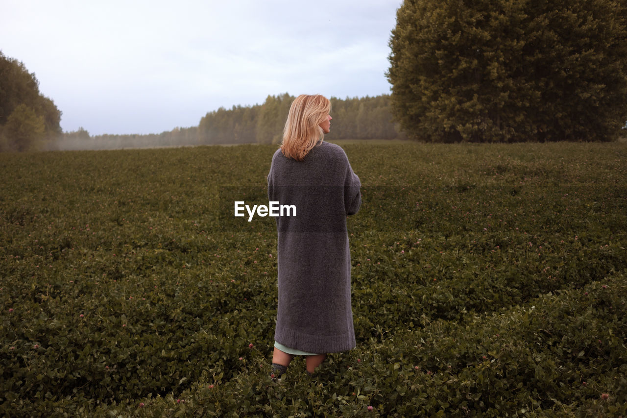 Young woman walking at countryside rear view