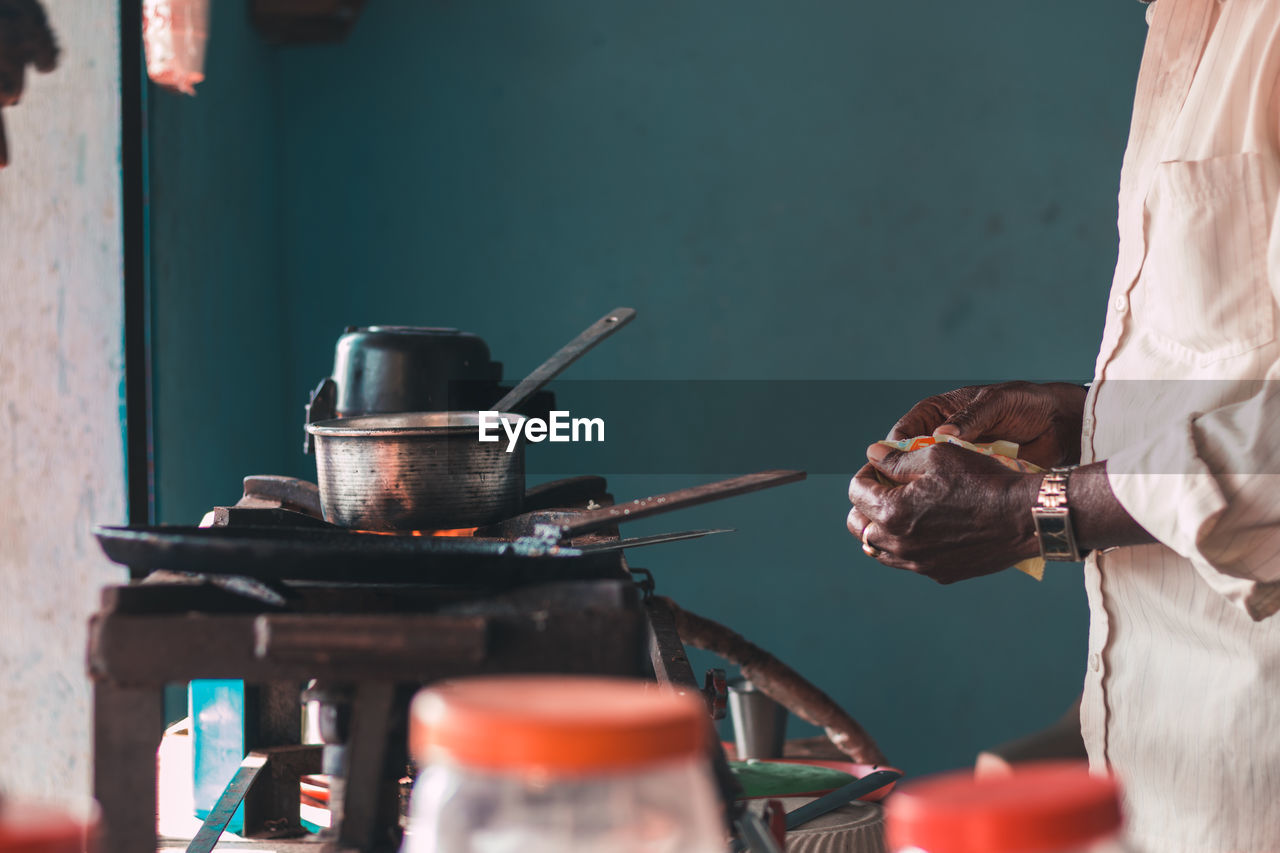 Midsection of man preparing food on stove