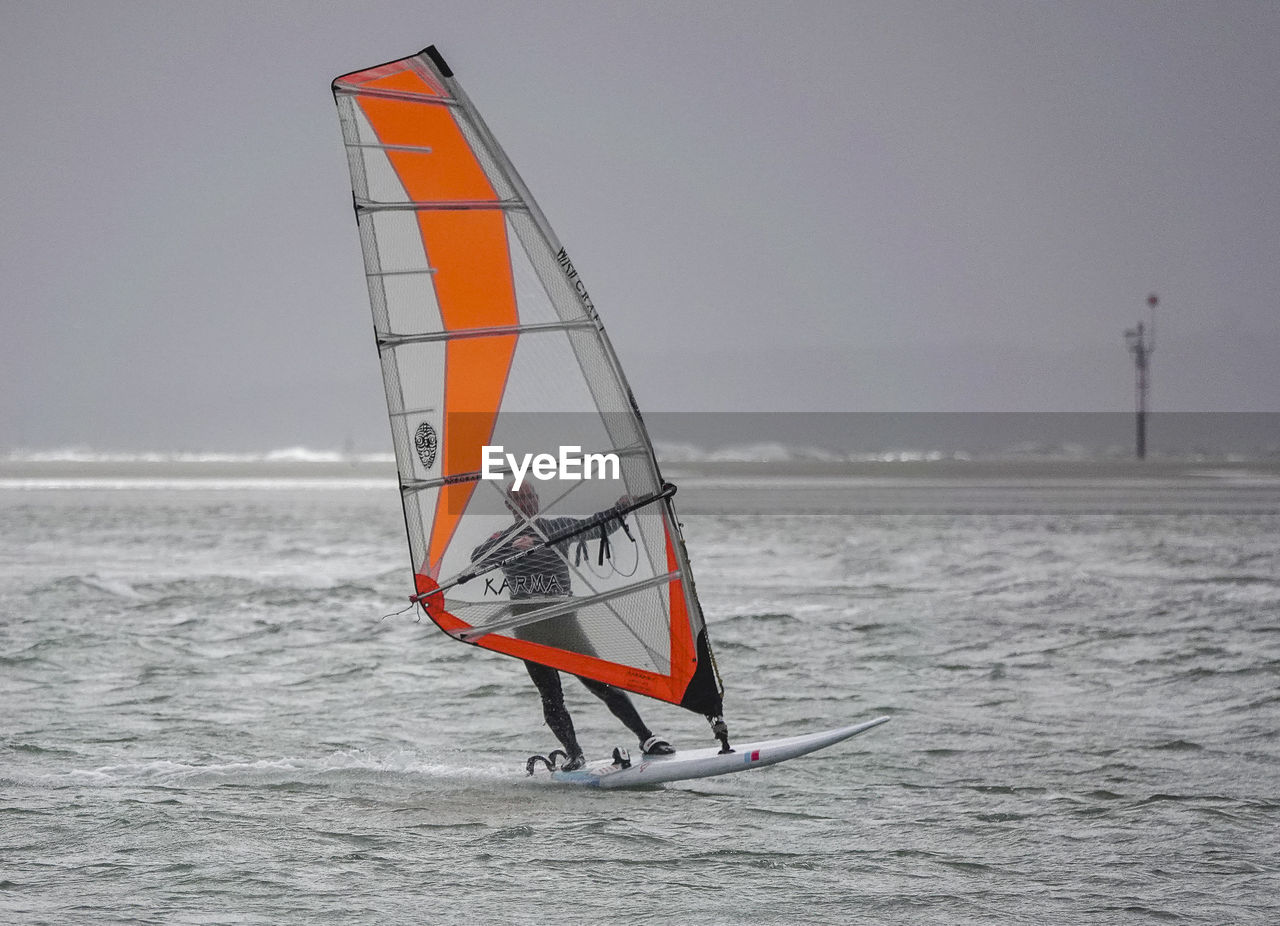 SAILBOAT IN SEA AGAINST SKY