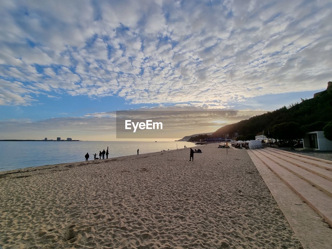 sky, land, beach, sea, water, horizon, shore, cloud, body of water, coast, nature, sand, scenics - nature, ocean, beauty in nature, sunset, holiday, travel destinations, travel, vacation, trip, sunlight, tranquility, tourism, environment, coastline, landscape, tranquil scene, summer, architecture, outdoors, sun, dusk, wave, horizon over water, seascape, blue, group of people, transportation, bay, water's edge, idyllic