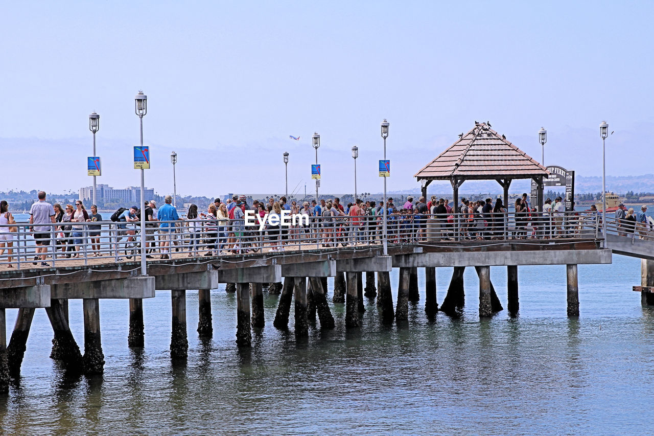 People on pier over river