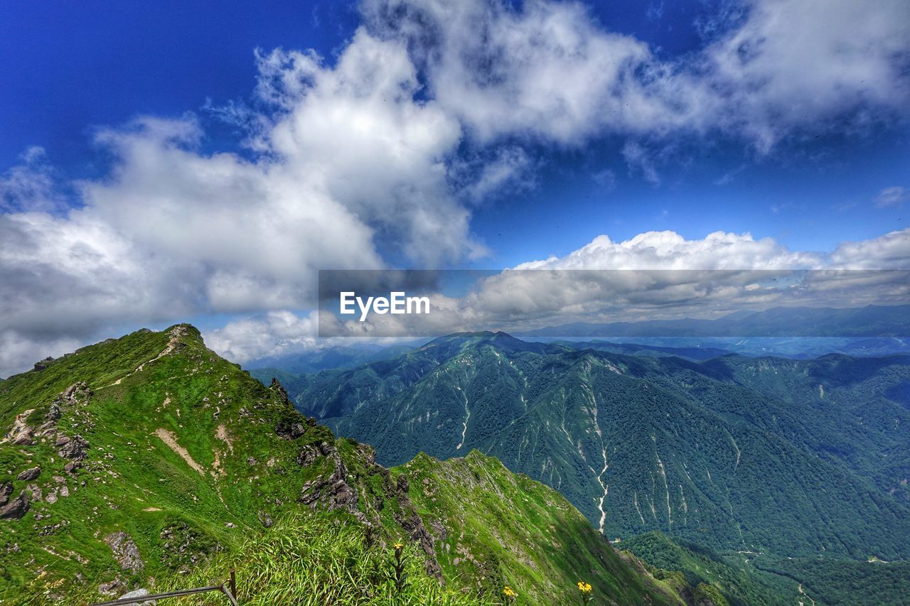 Scenic view of mountains against blue sky