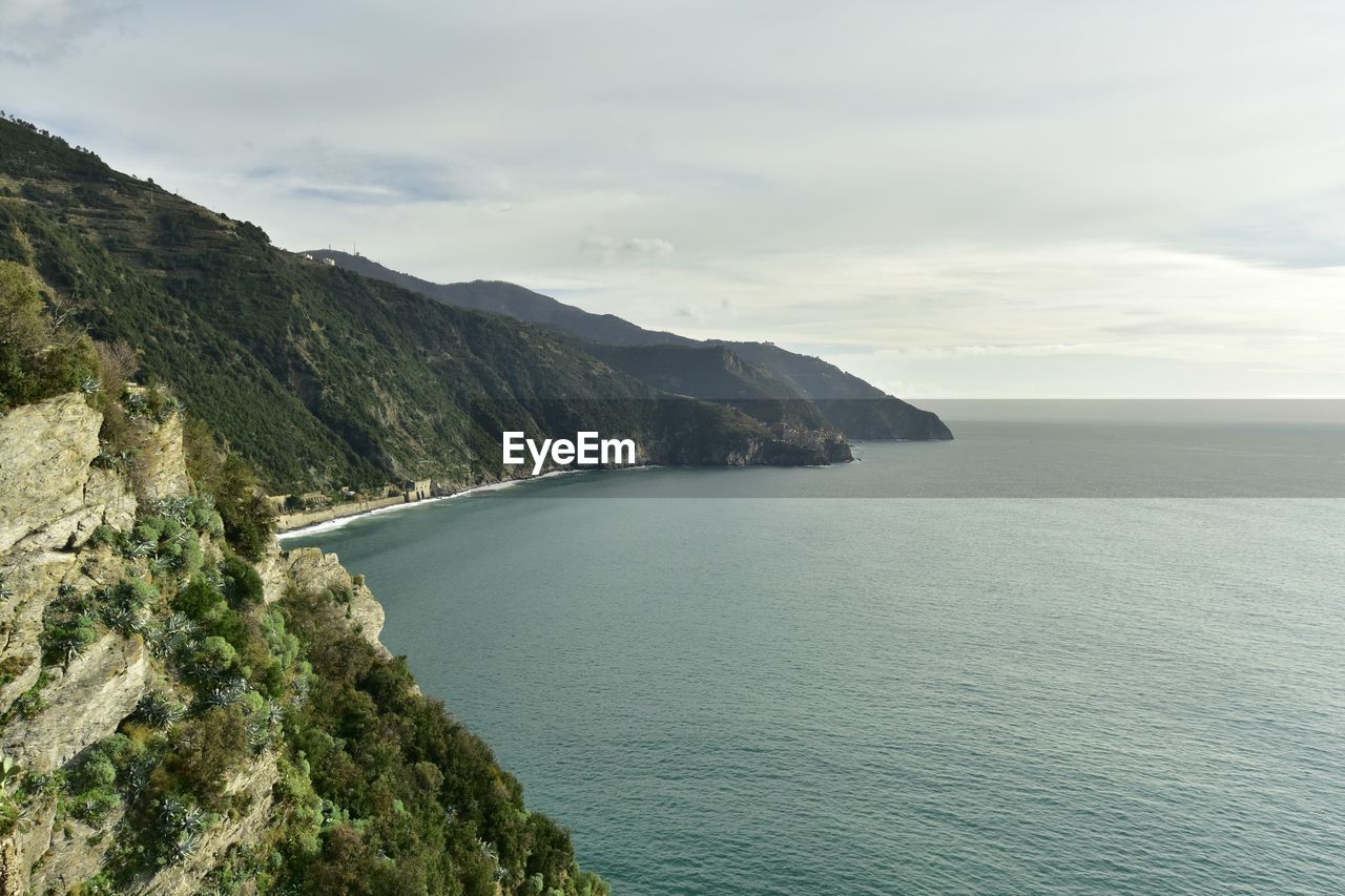 Scenic view of sea and mountains against sky