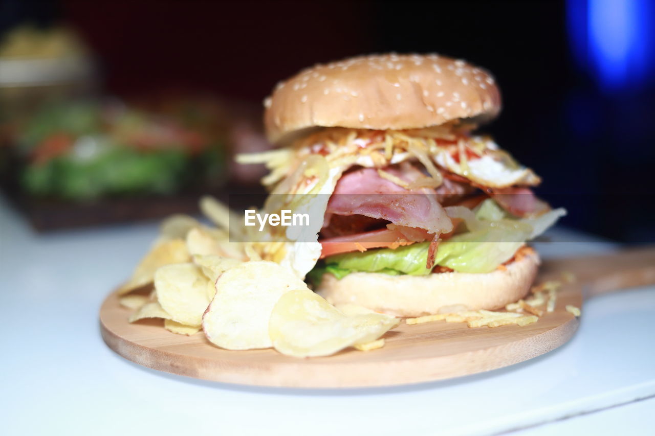 CLOSE-UP OF BURGER ON TABLE
