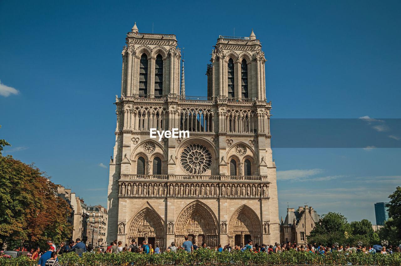 People and the gothic facade of notre-dame cathedral in paris. the famous capital of france.