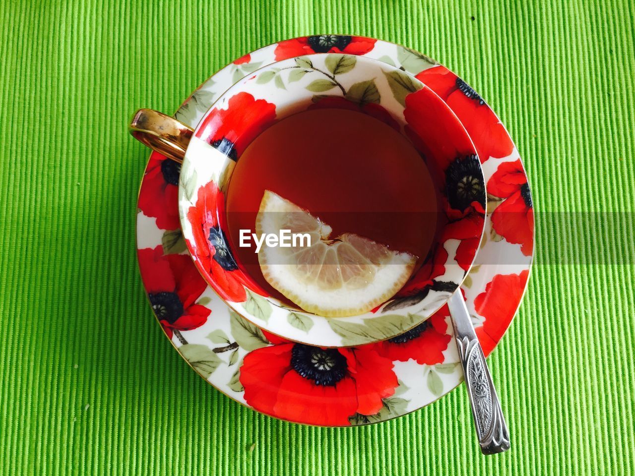Cup and saucer of lemon tea with teaspoon