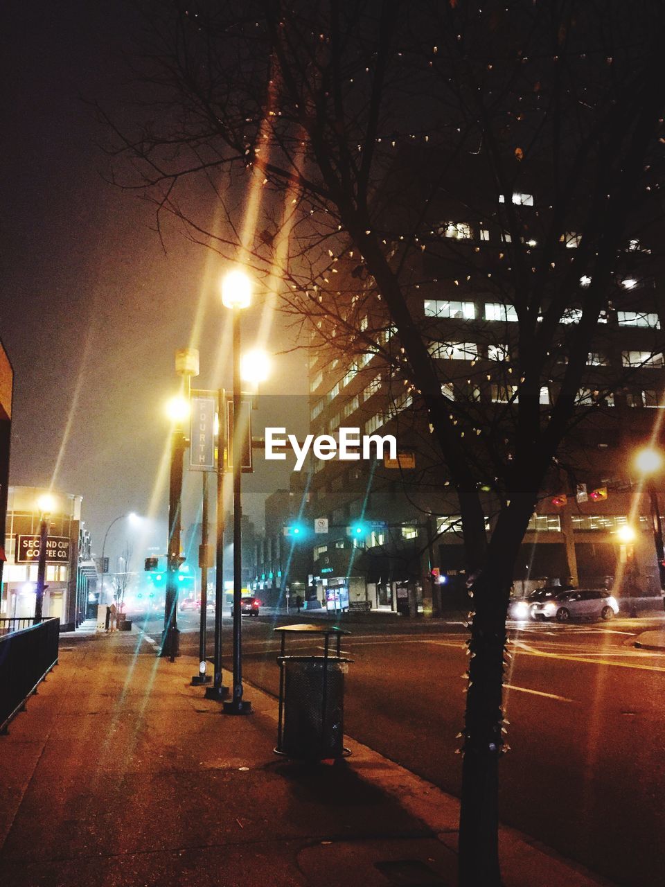 ILLUMINATED STREET LIGHTS IN CITY AGAINST SKY AT NIGHT