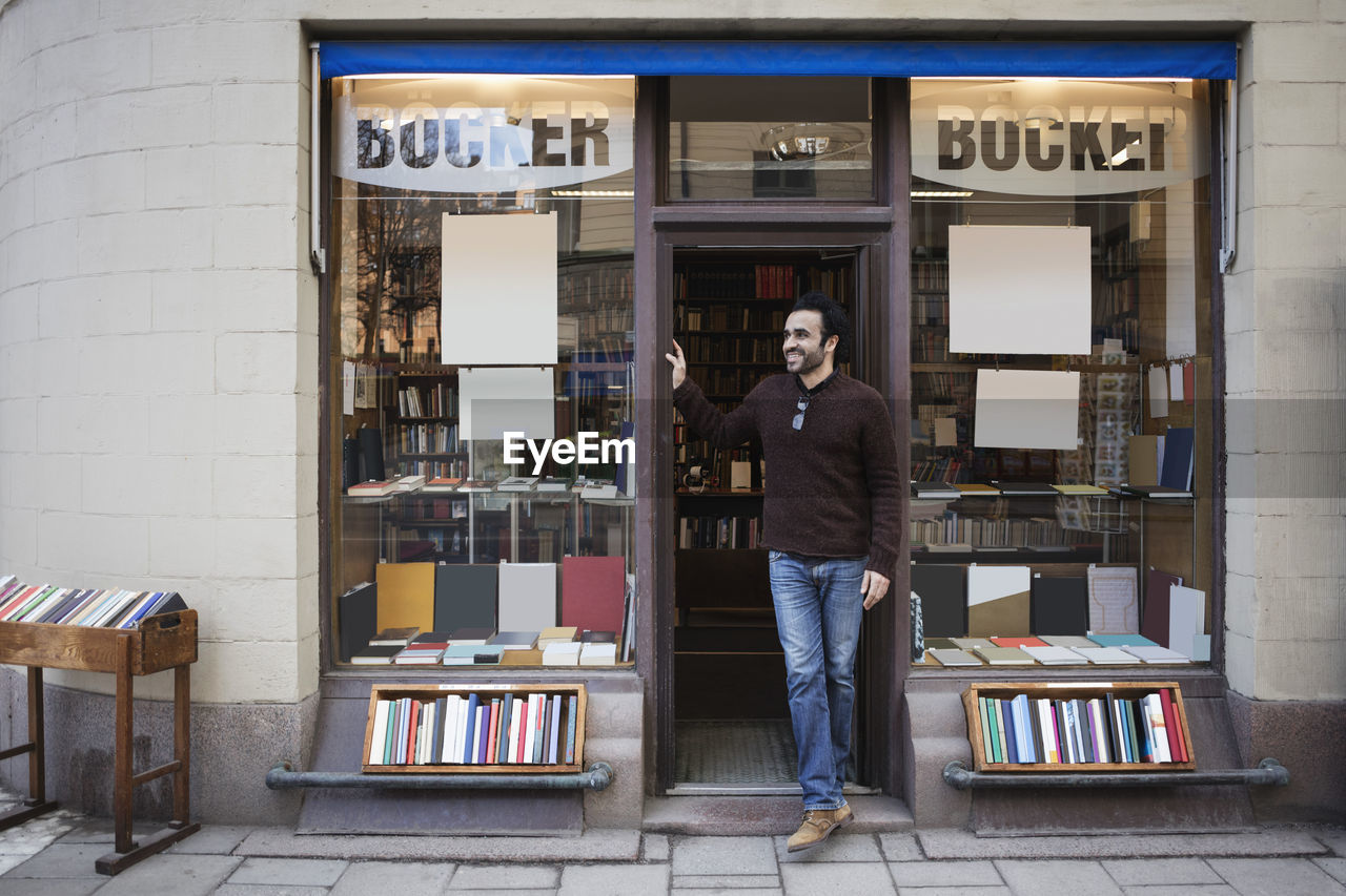 Male librarian looking away while standing at doorway