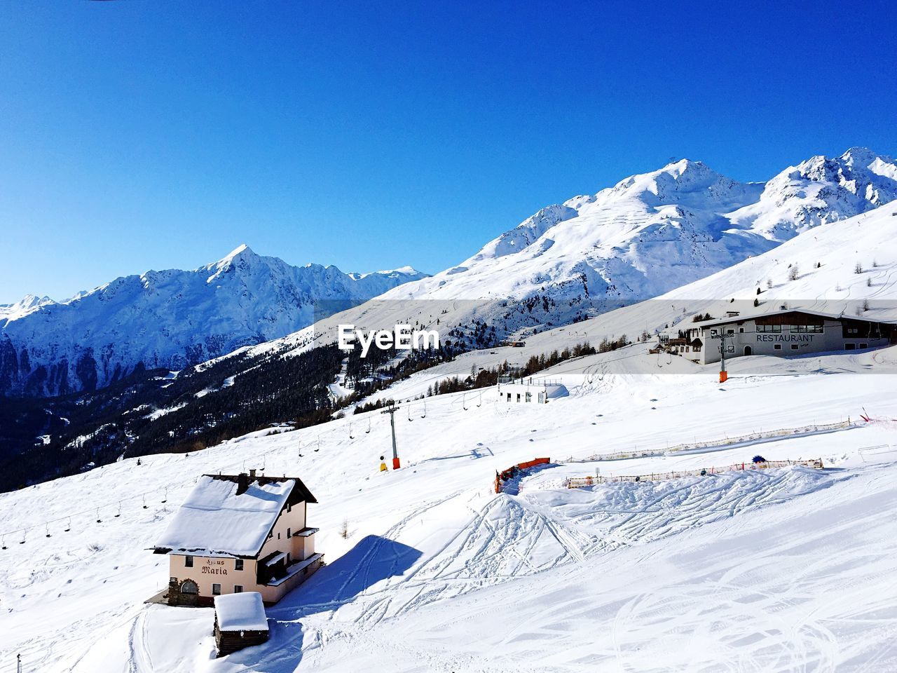 Scenic view of snowcapped mountains against clear blue sky