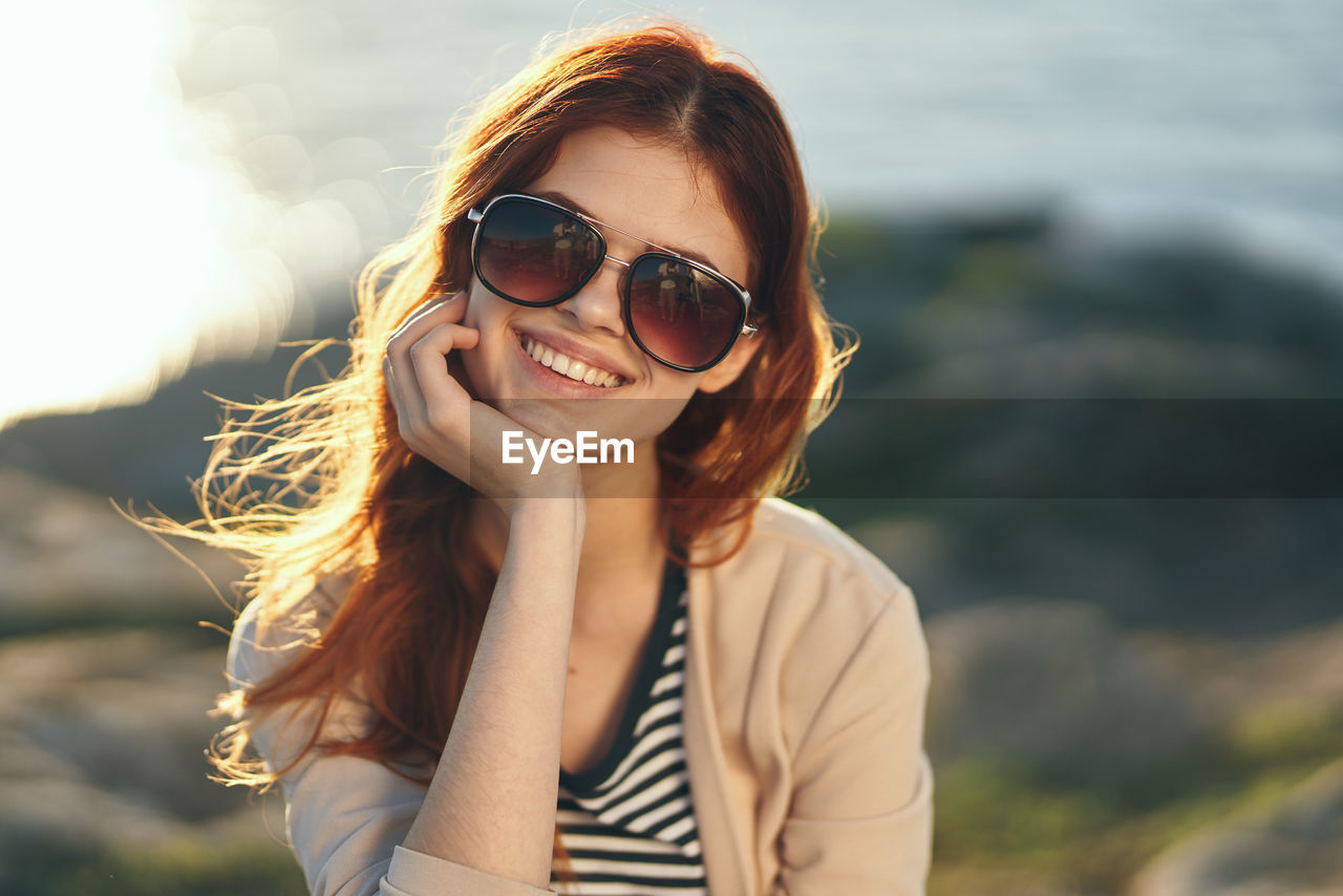 Portrait of smiling young woman wearing sunglasses