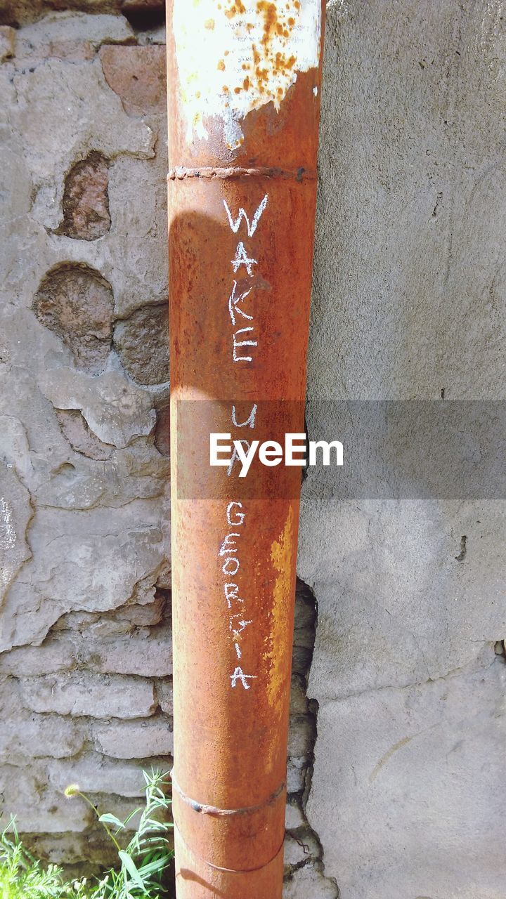 CLOSE-UP OF TEXT ON STONE WALL