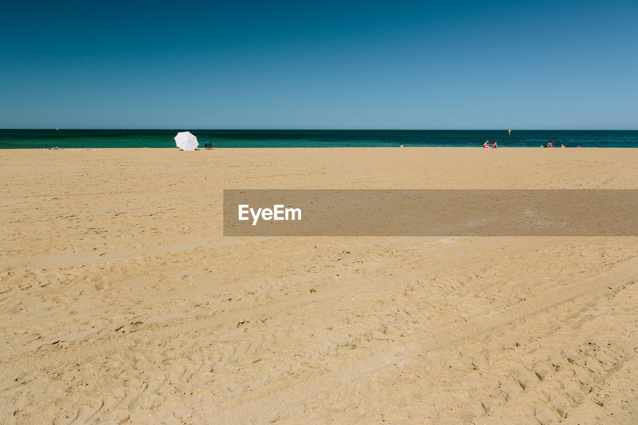 Tourists on beach against sky