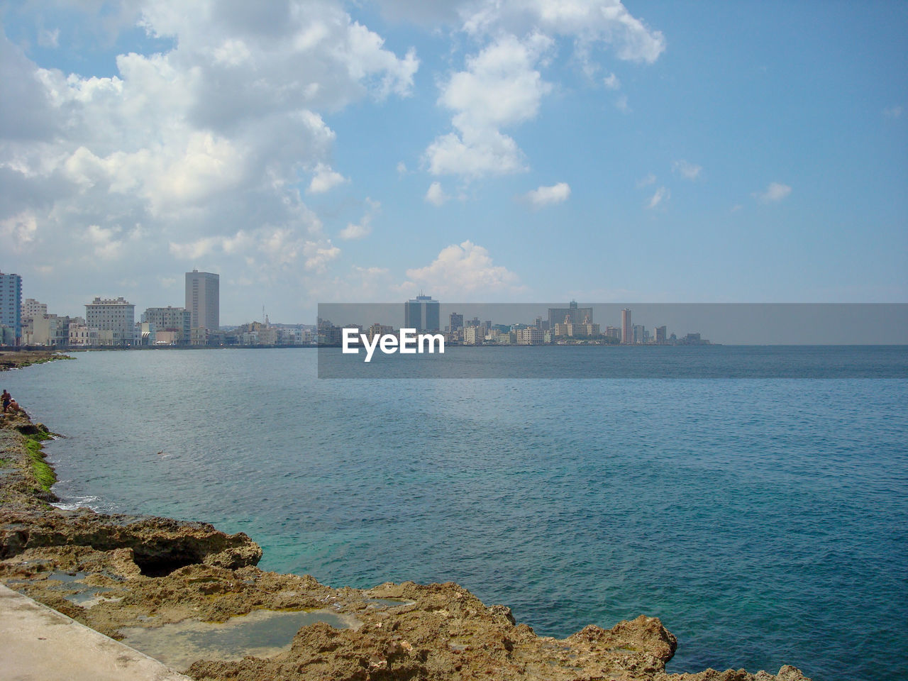 Scenic view of sea by buildings against sky