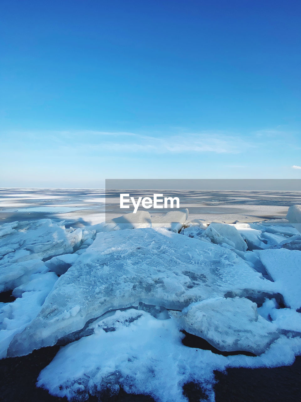 Scenic view of frozen sea against blue sky