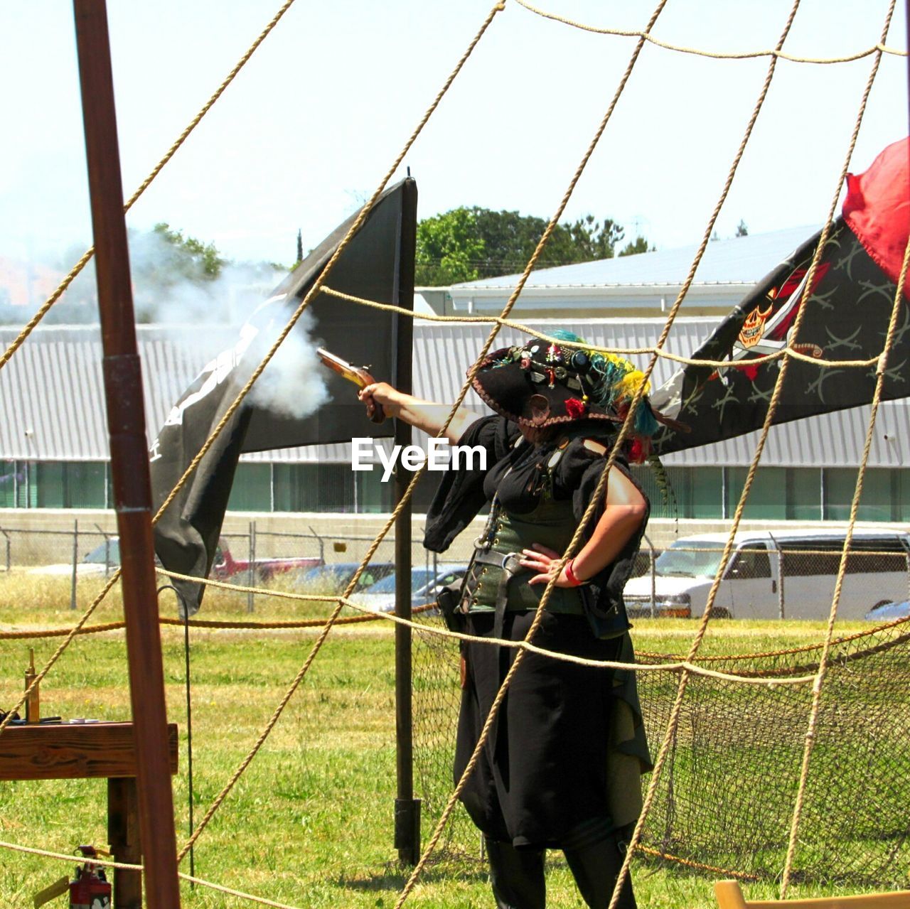 REAR VIEW OF MAN STANDING AT FARM