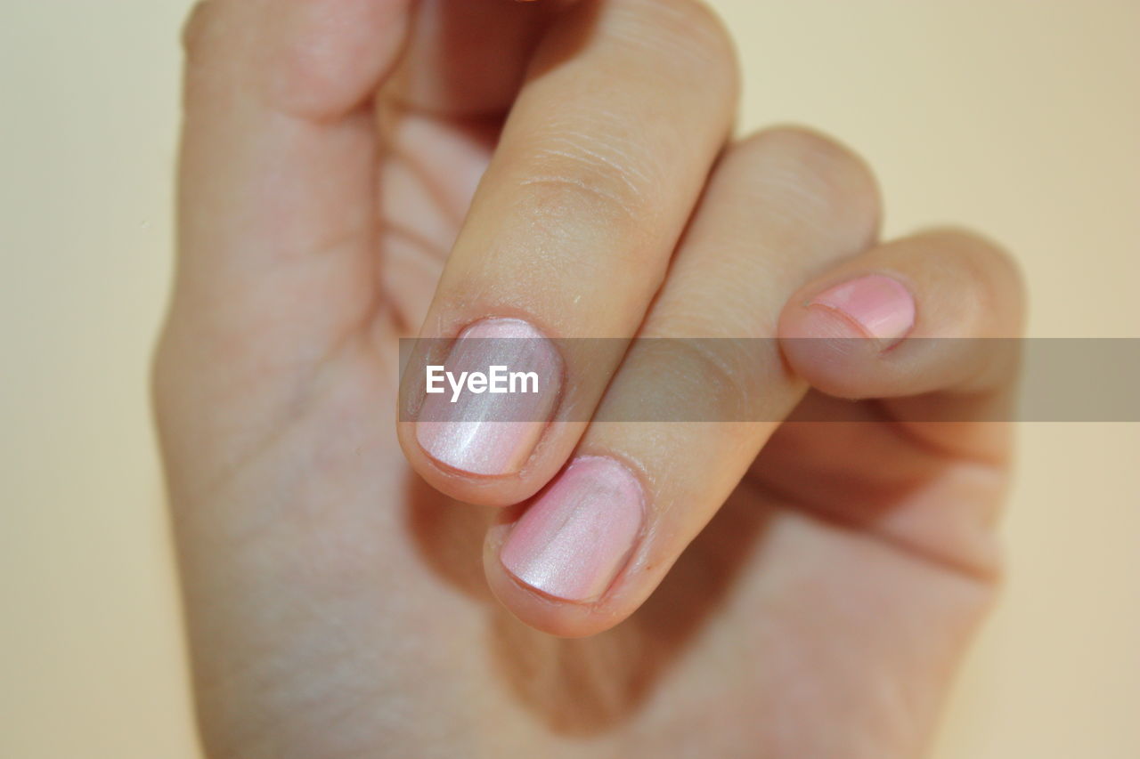 Close-up of woman hand with pink fingernail