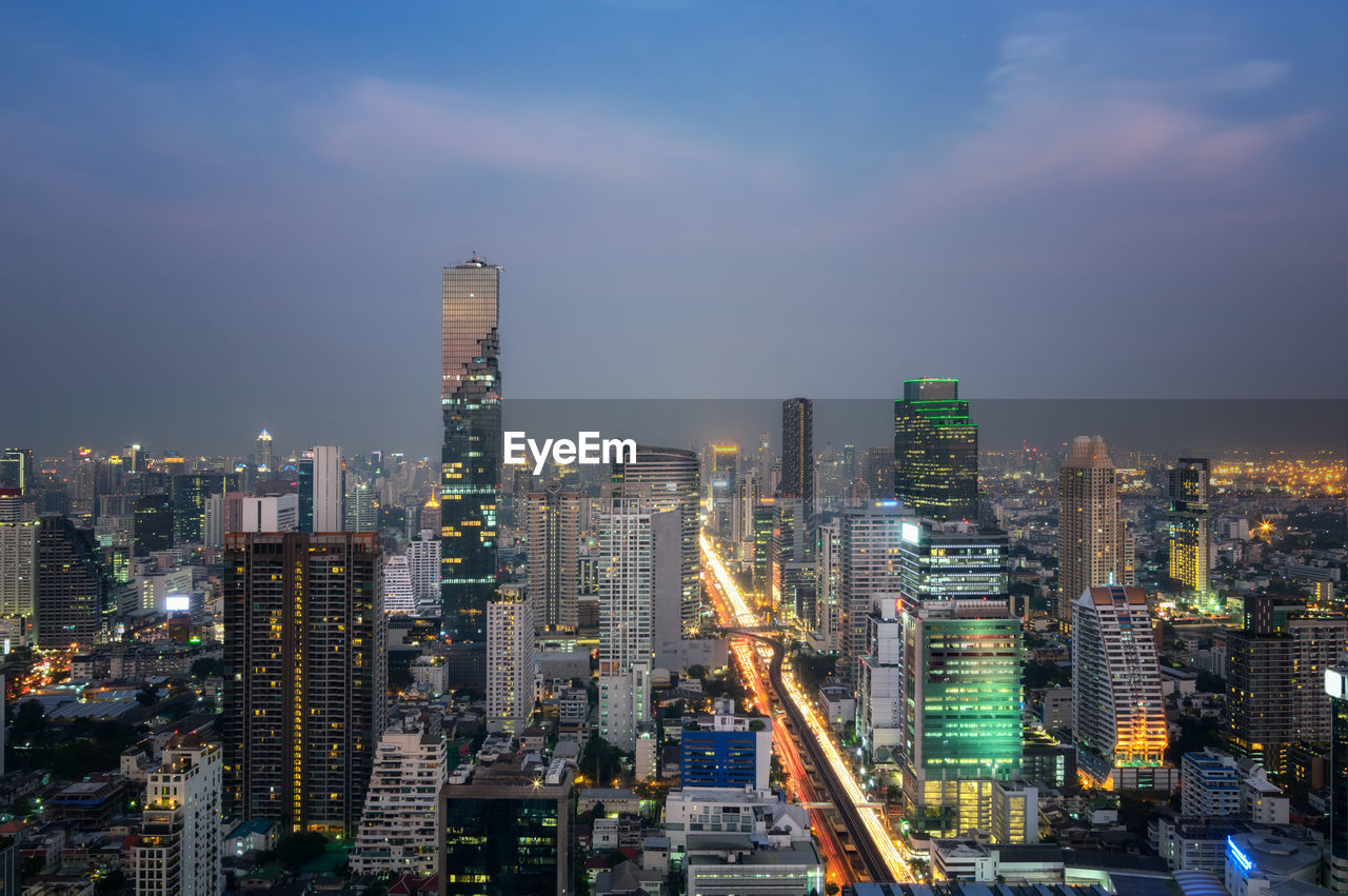 Illuminated buildings in city against sky