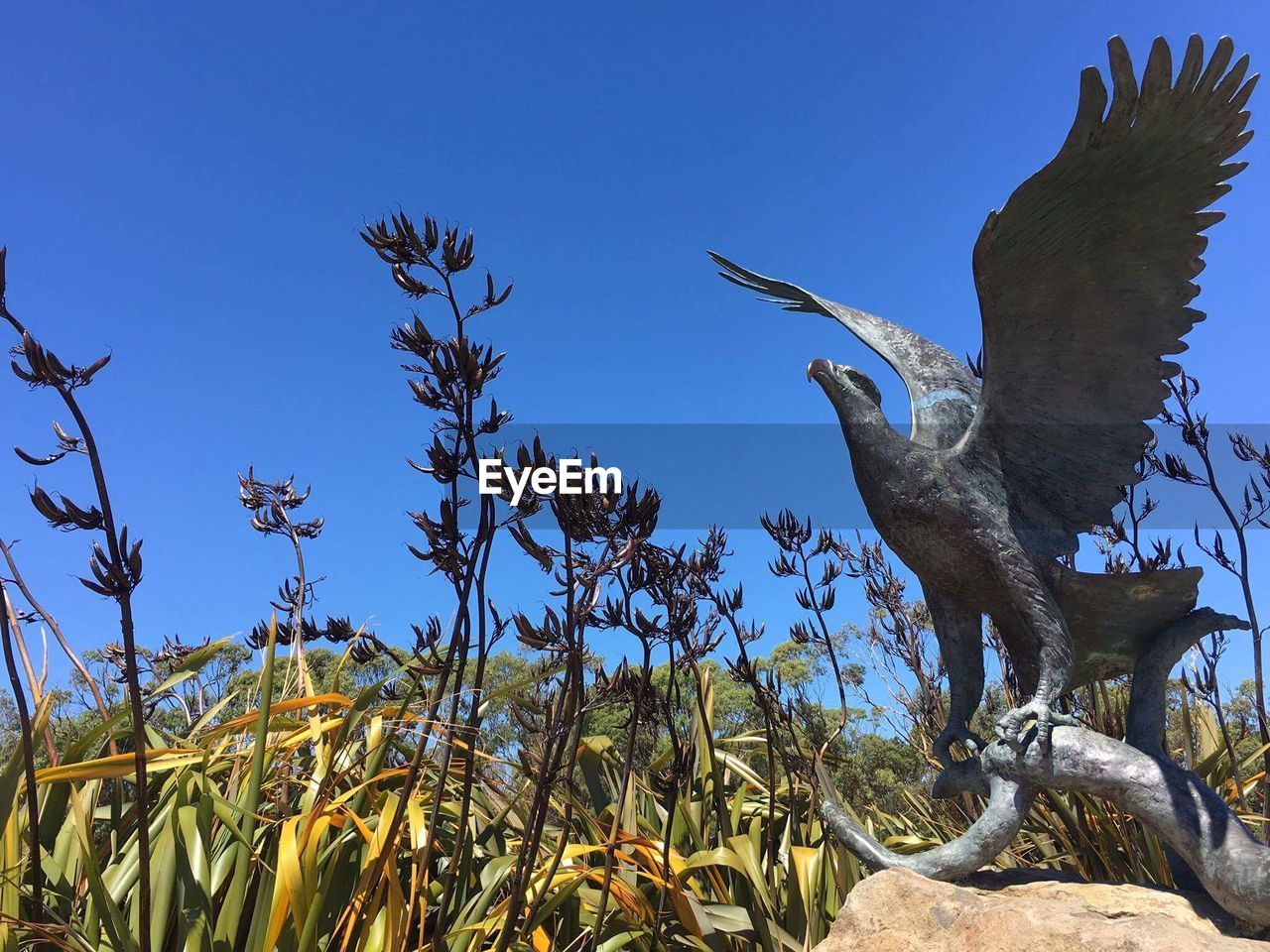 Bird statue against blue sky