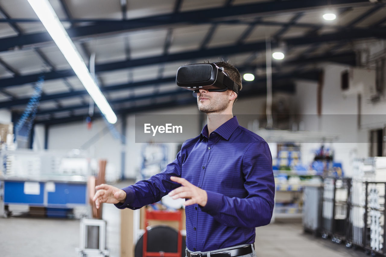 Company employee wearing vr goggles in shop floor