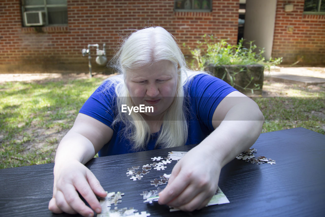 Woman placing a puzzle piece into the correct spot