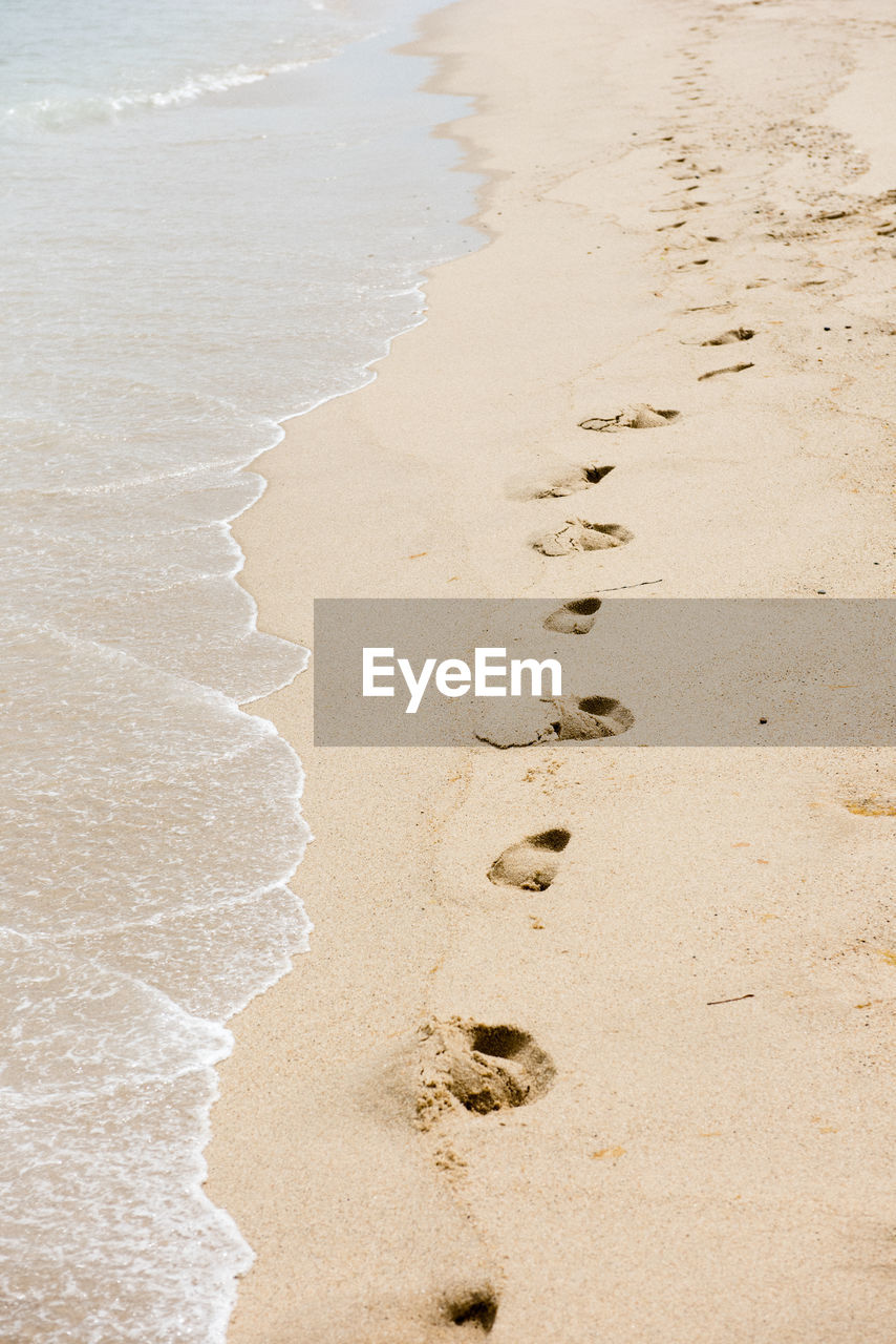 Footprints in the sand along an isolated beach