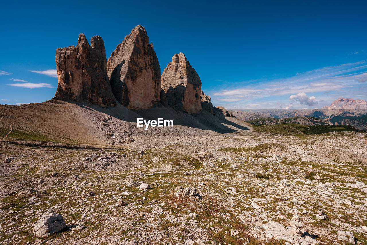 Panoramic view of rocky mountains against blue sky