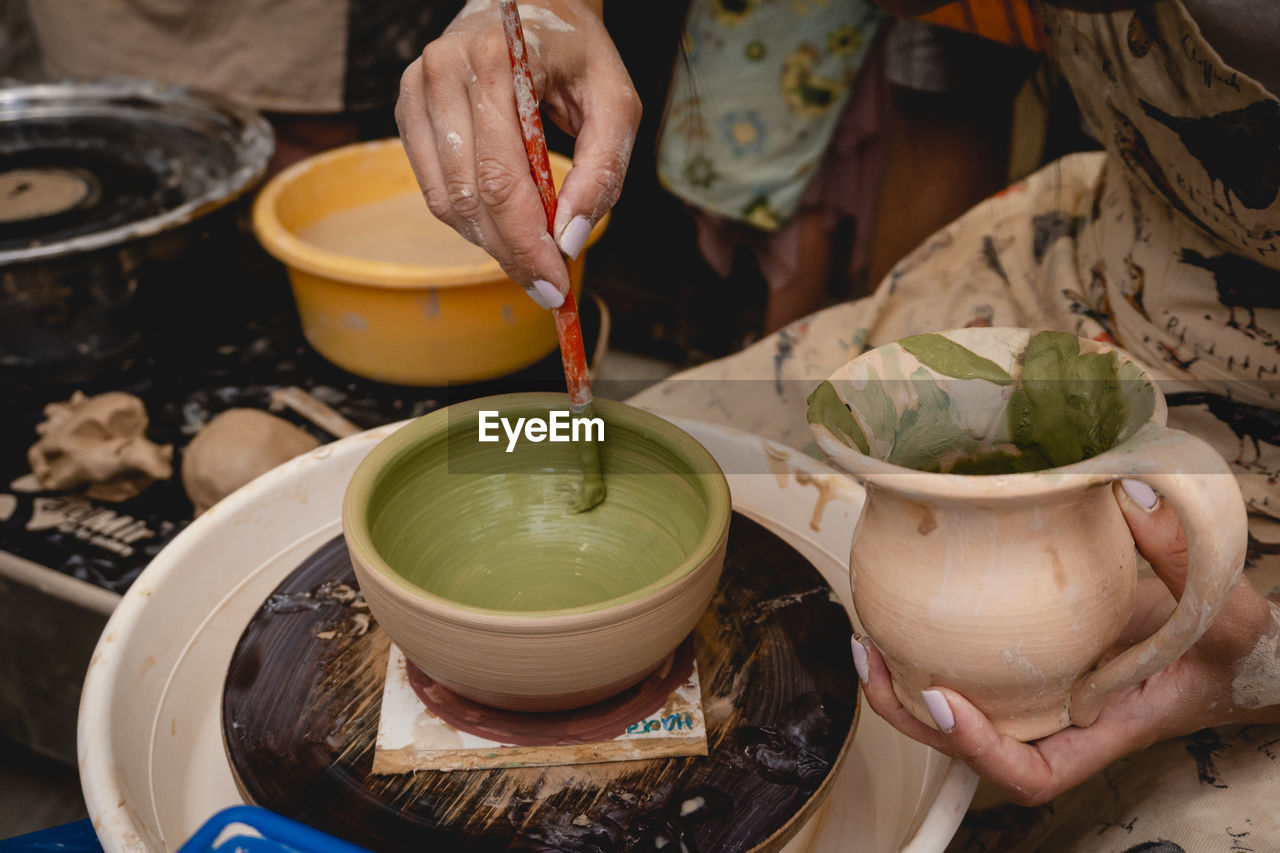 CLOSE-UP OF PERSON PREPARING FOOD IN KITCHEN