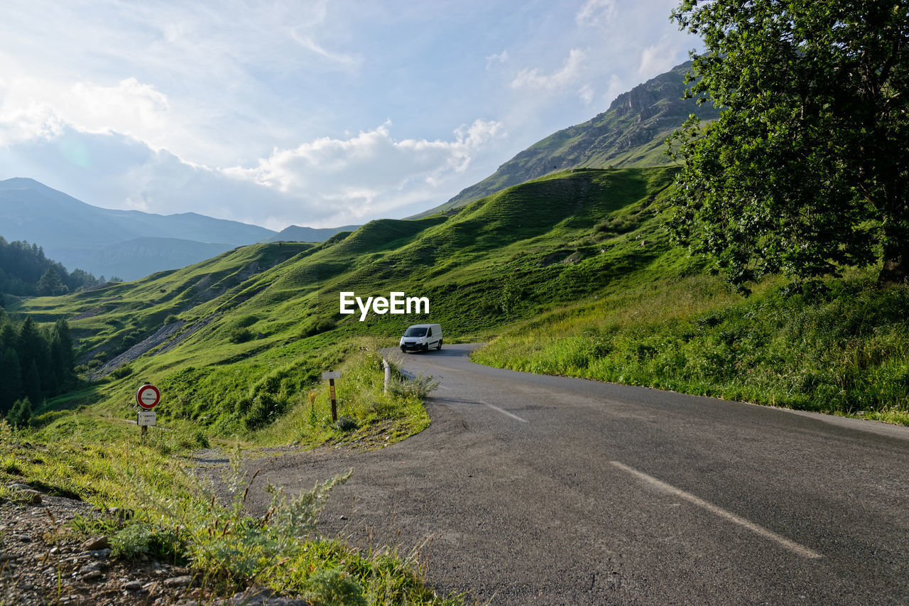 Road amidst green mountains against sky