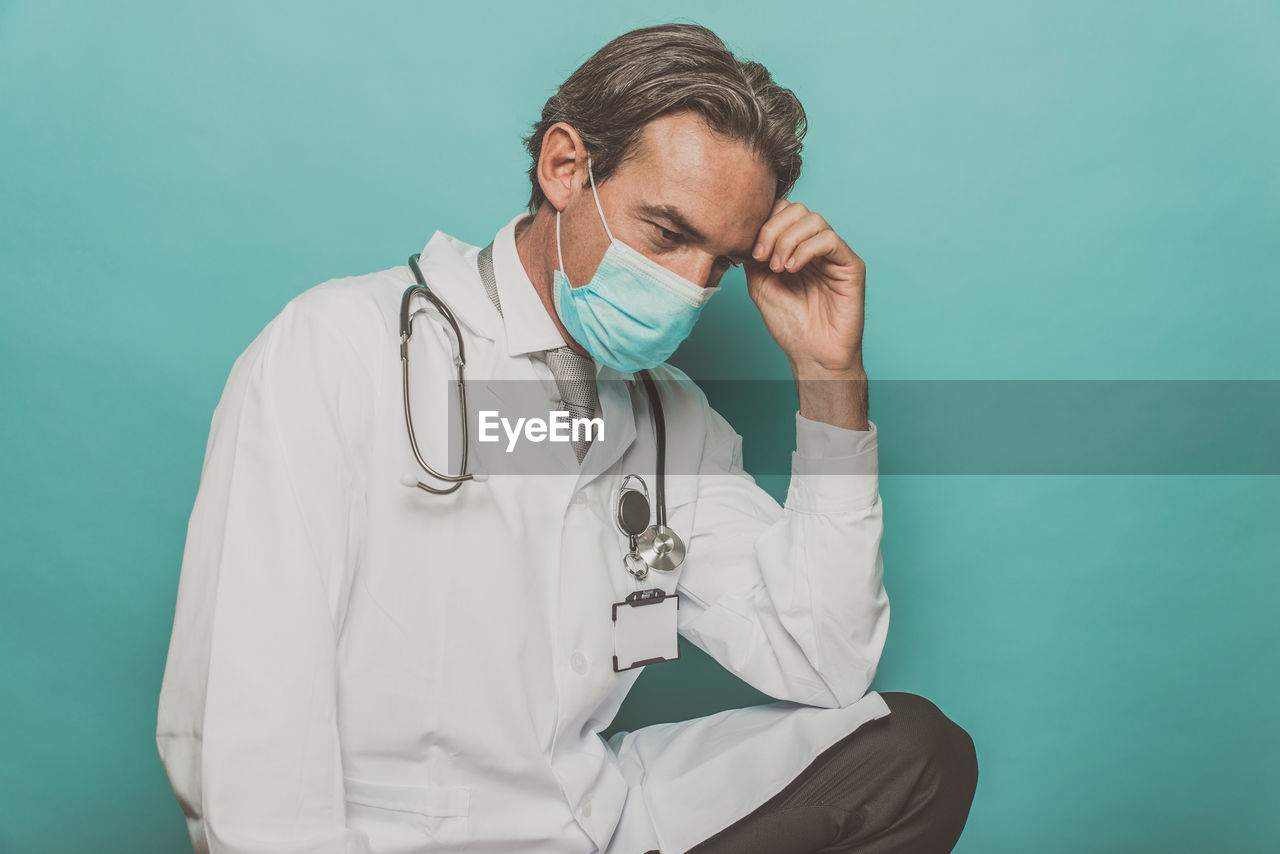 Doctor wearing mask against colored background
