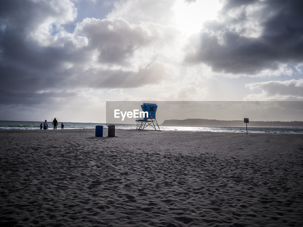 Scenic view of beach against cloudy sky