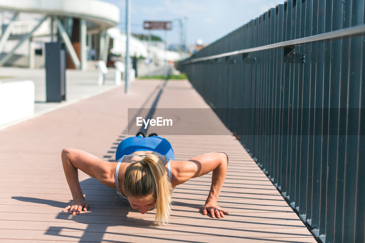 Young woman doing pushups outdoors