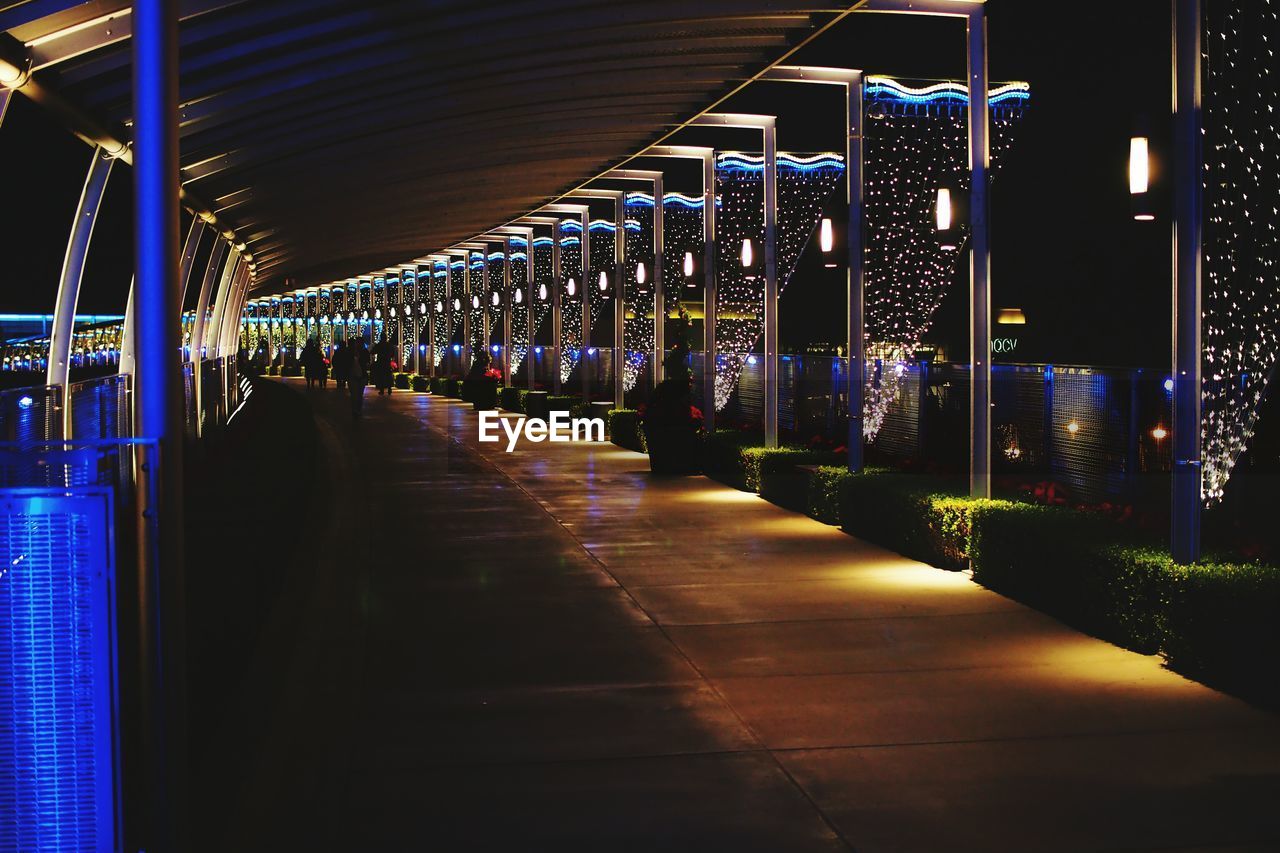 People walking on illuminated footpath