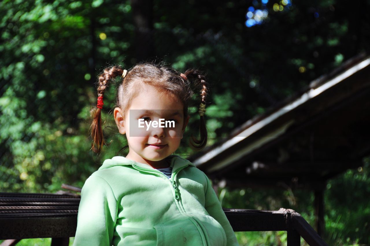 Portrait of cute girl sitting on bench