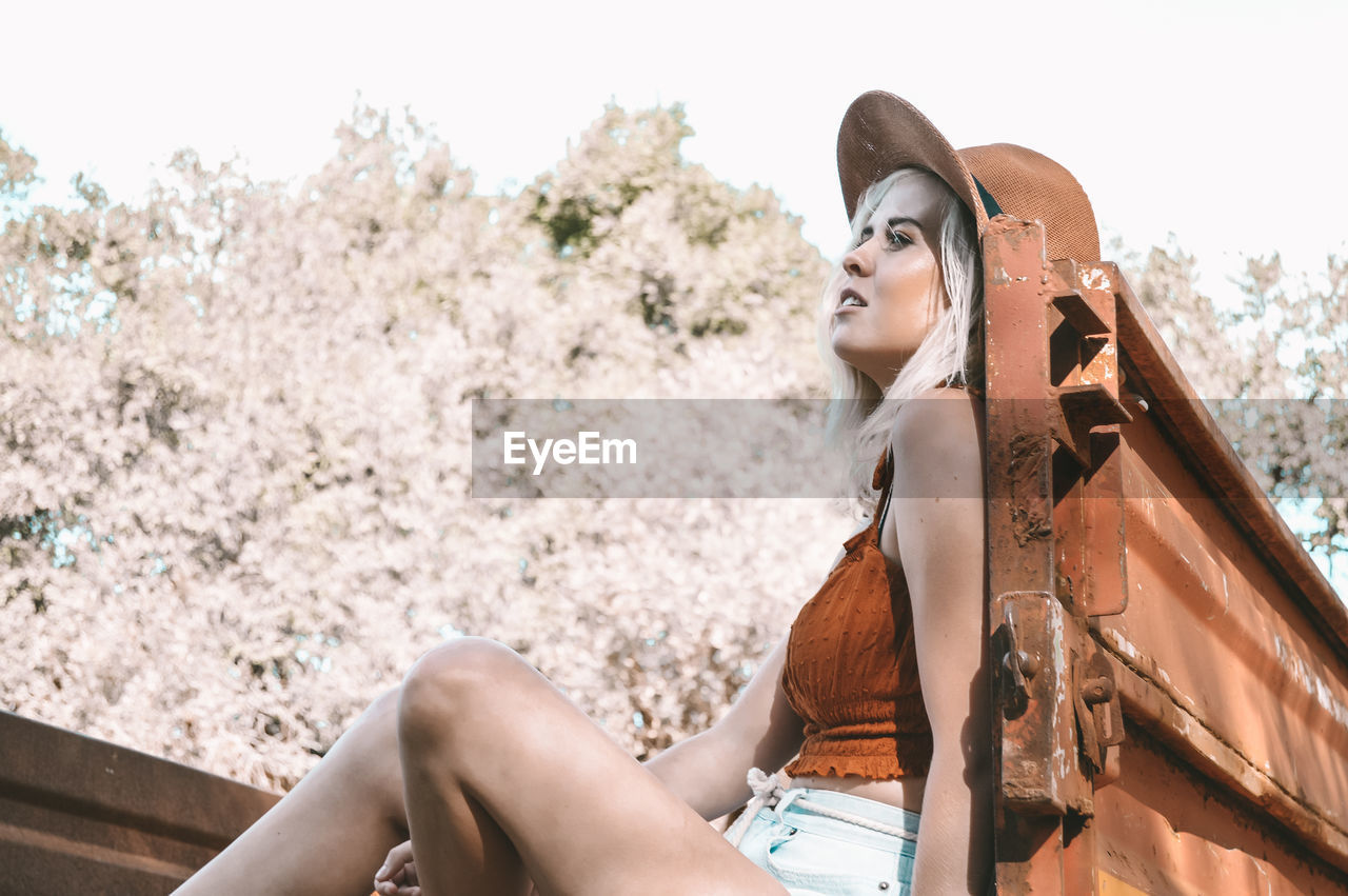 Young woman looking away while sitting in truck