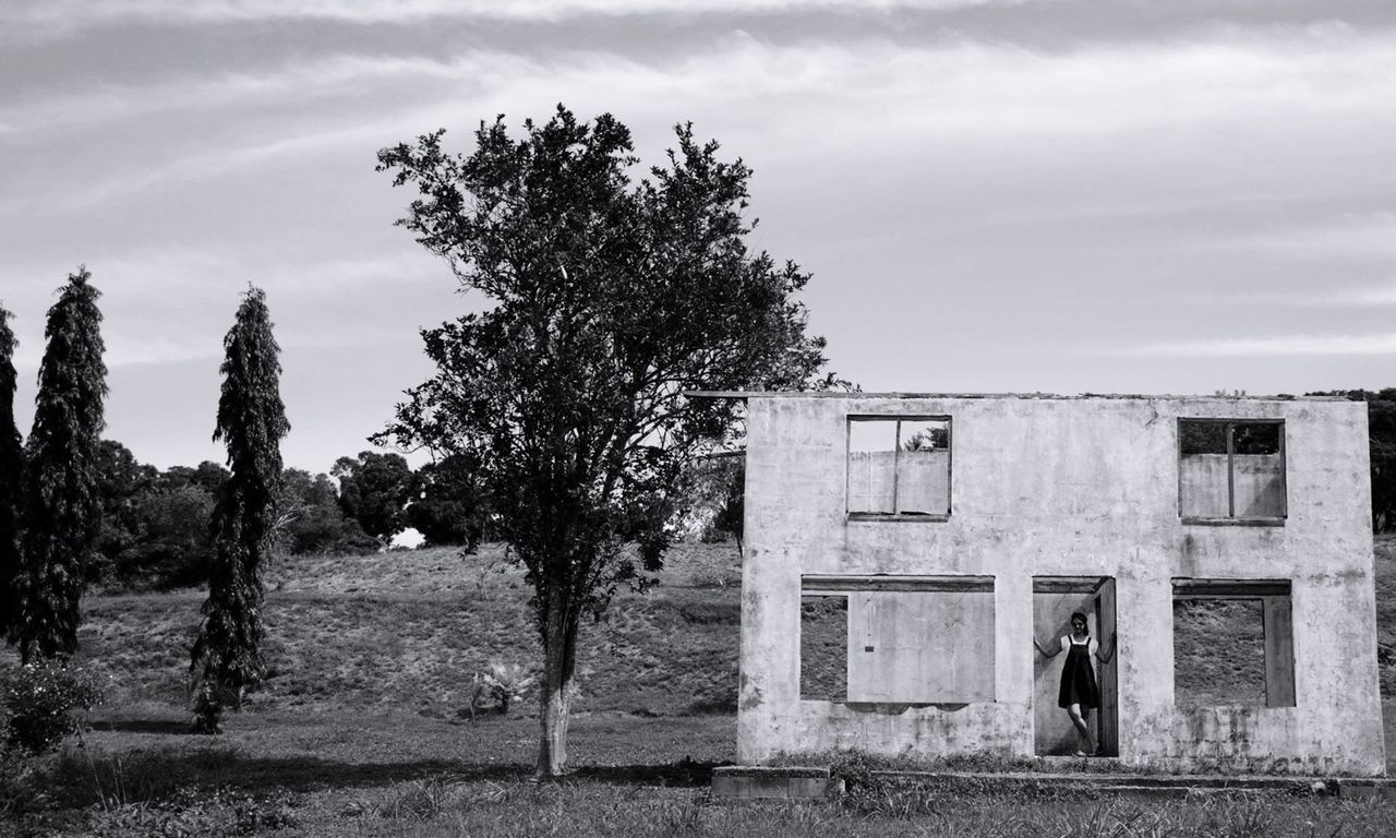 BUILT STRUCTURE ON LANDSCAPE AGAINST CLOUDY SKY