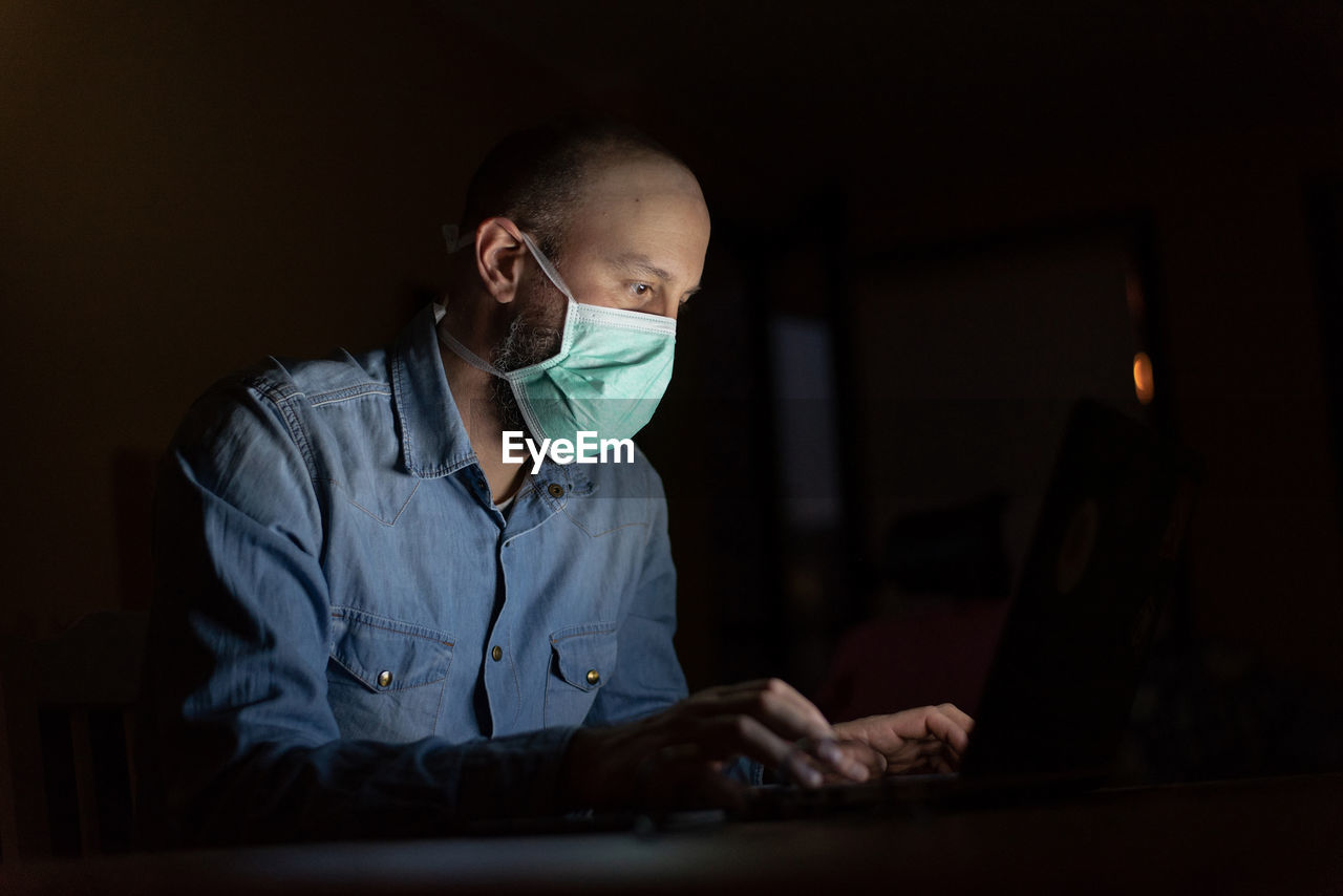 Man wearing mask working in darkroom