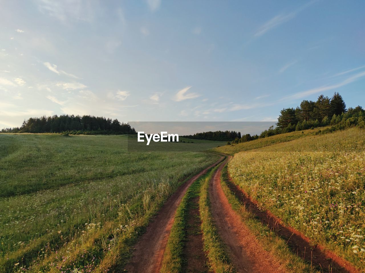 Country road near the slope against the background of the evening sky