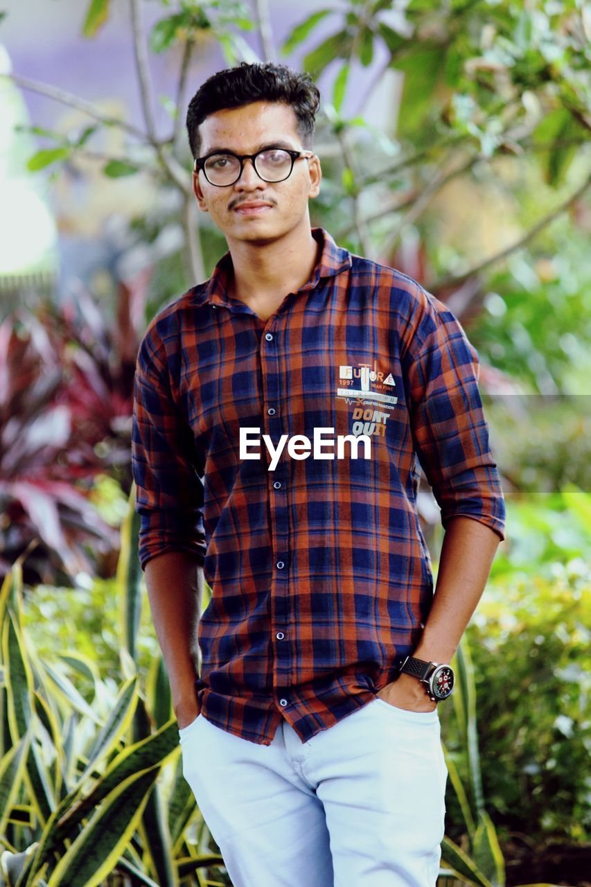 Portrait of young man standing in forest