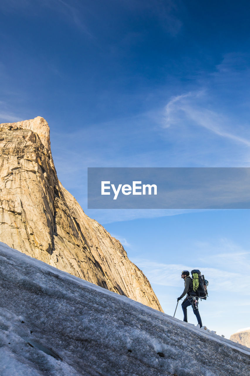 Backpacker ascending glacier on baffin island, canada.