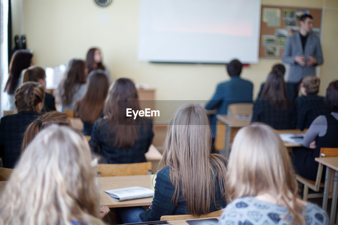 Rear view of students sitting in classroom