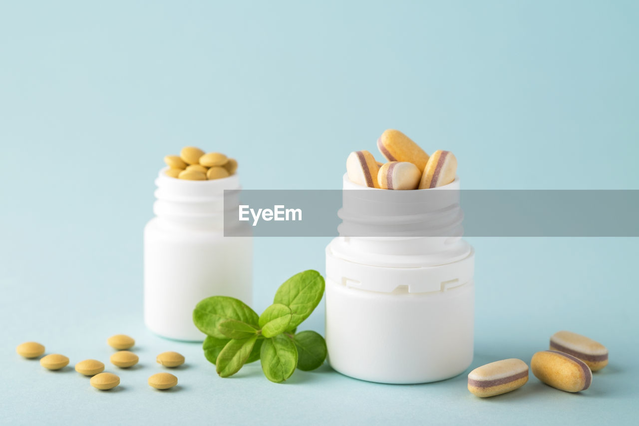 Vitamins and herbal supplements in jars with a green plant. dietary supplements.
