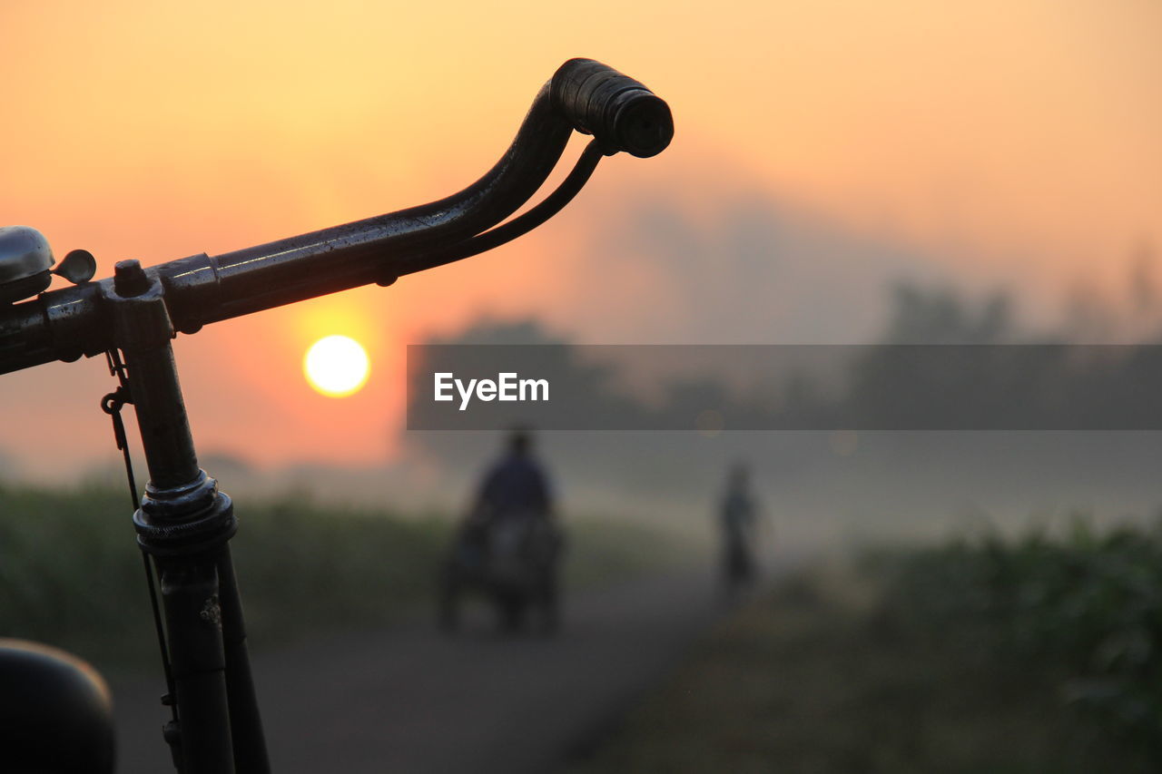 Close-up of bicycle against sky during sunset