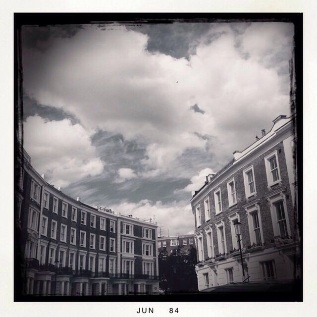 LOW ANGLE VIEW OF BUILDINGS IN CITY AGAINST CLOUDY SKY